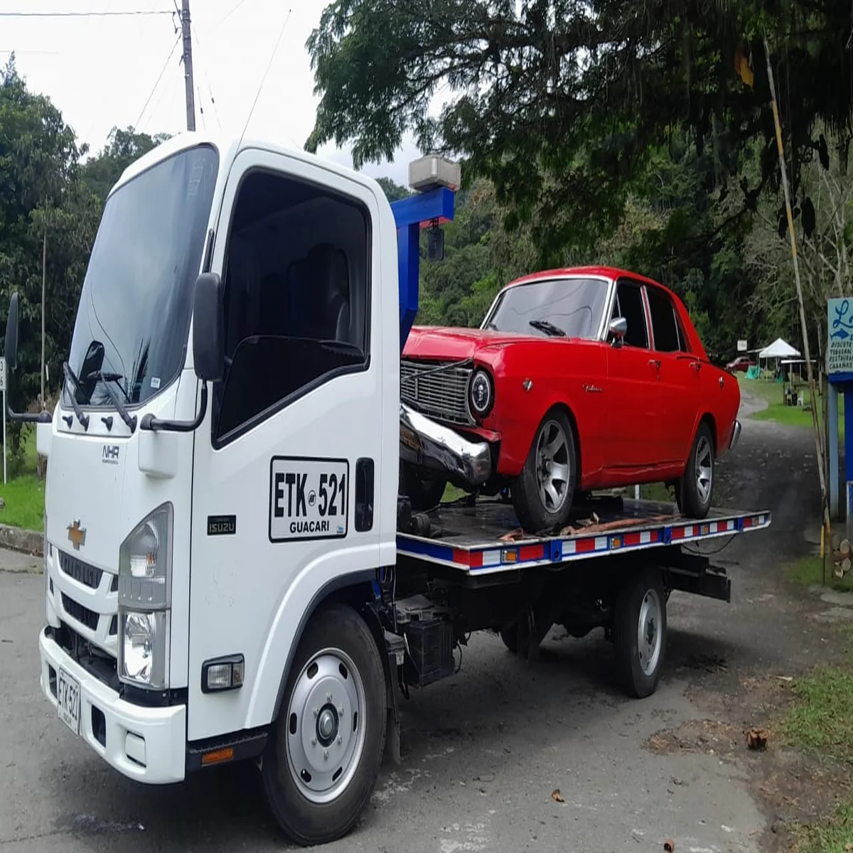 Grúa en Cali remolcando automóvil clásico rojo