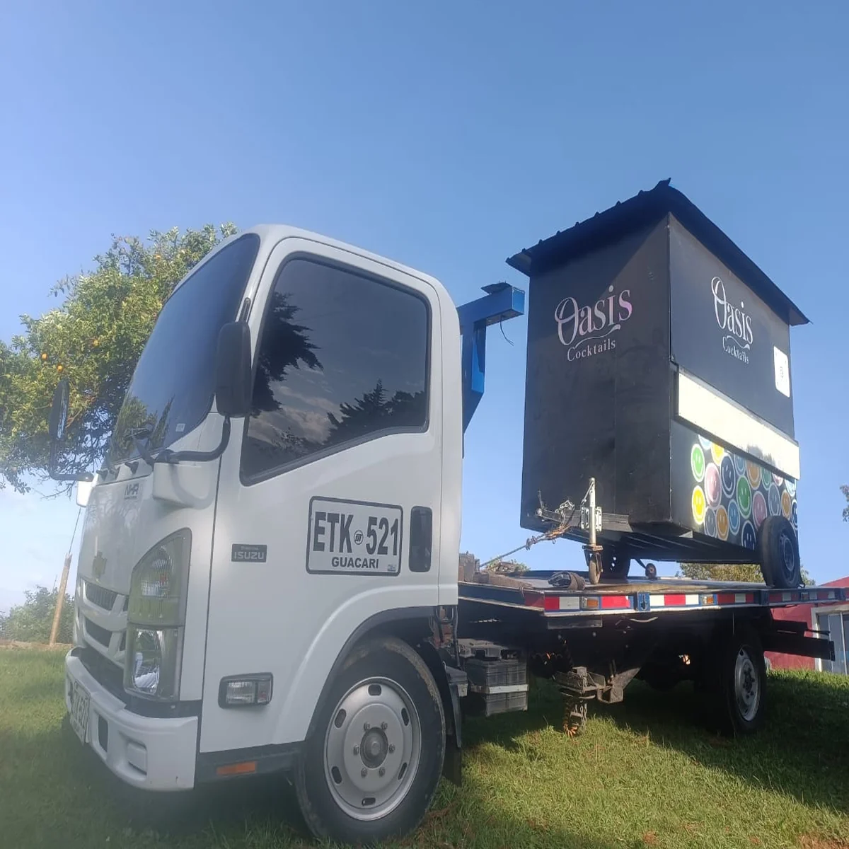 Servicio de grúa en Cali transportando remolque comercial Oasis Cocktails